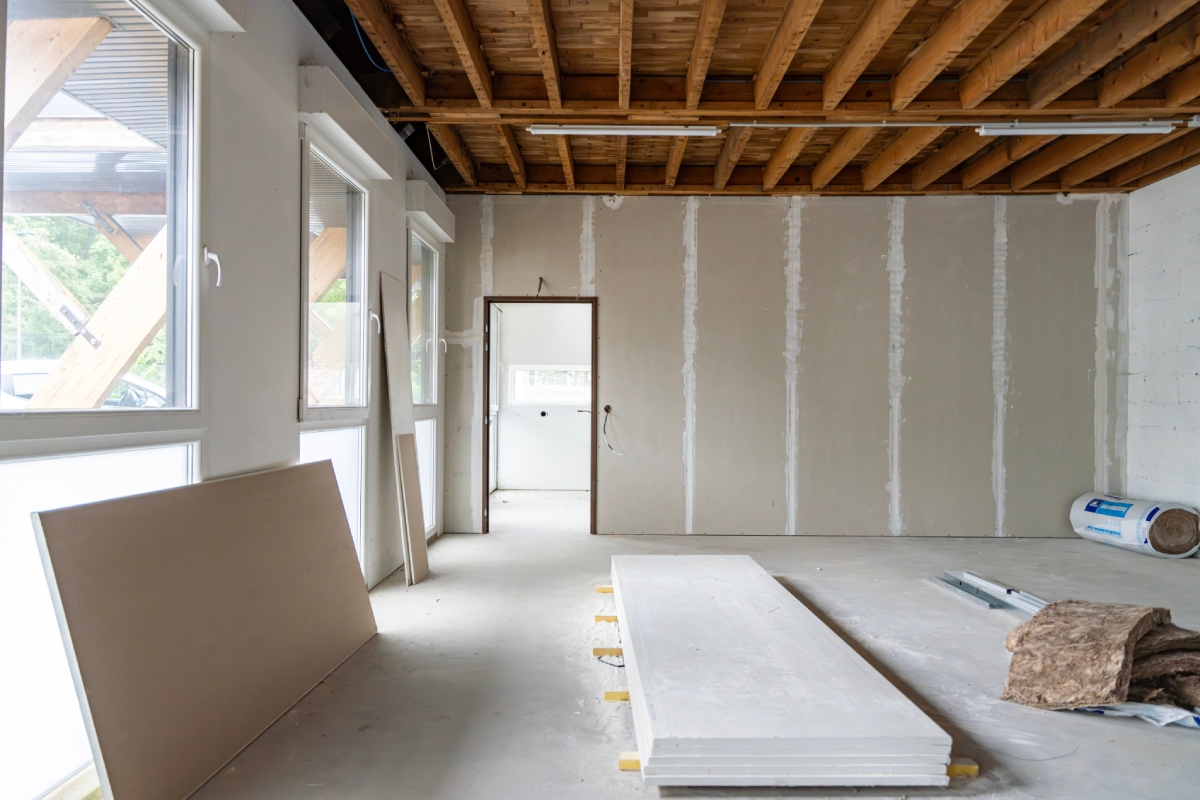 Pièce en rénovation pour valorisation immobilière, baies vitrées et matériaux de chantier