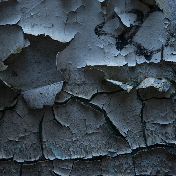Gros plan d'un mur ancien aux peintures écaillées, illustration diagnostic plomb